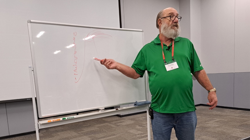 Ted Matthews talking while pointing to a whiteboard