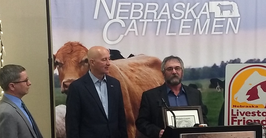 Buffalo County commissioner Ron Loeffelholz holding the Livestock Friendly certificate for the county 