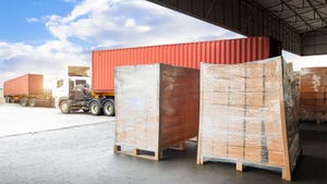 Stacked boxes wrapped in plastic on pallets being loaded onto shipping containers