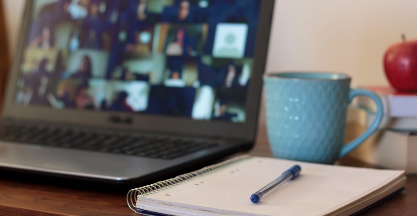 notebook with pen resting on top with laptop in background