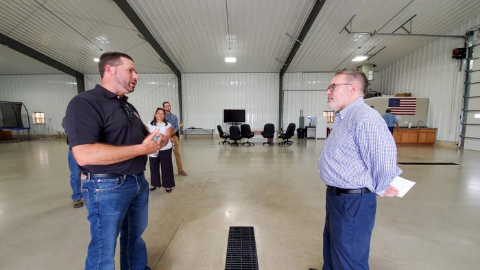 Frank Burkett and Andrew Wheeler talking in a large office space at Kellogg Farms