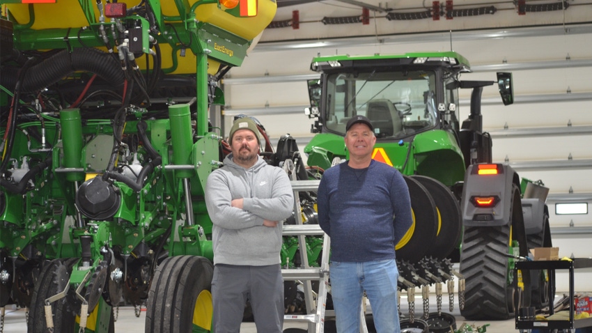 Rick Christiansen and his son Brandon standing in front of tractors