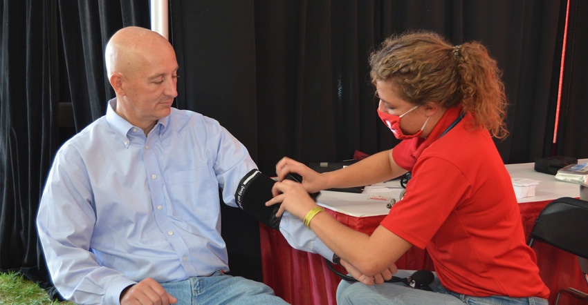 A nursing student from UNMC College of Nursing takes the blood pressure of Gov. Pete Ricketts during the 2021 Husker Harvest 