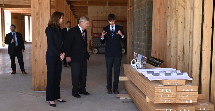  Scott and Molly Cutler with Cutler Development, show Secretary Vilsack what mass timber wood  looks like