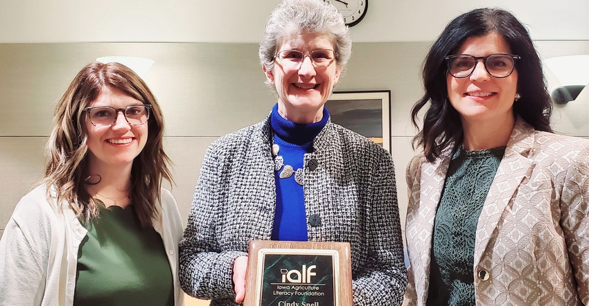 Waukee APEX ag and bio science teacher Cindy Snell holding awardwith Bre Wagner, IAF board president and Kelly Foss, IALF exe