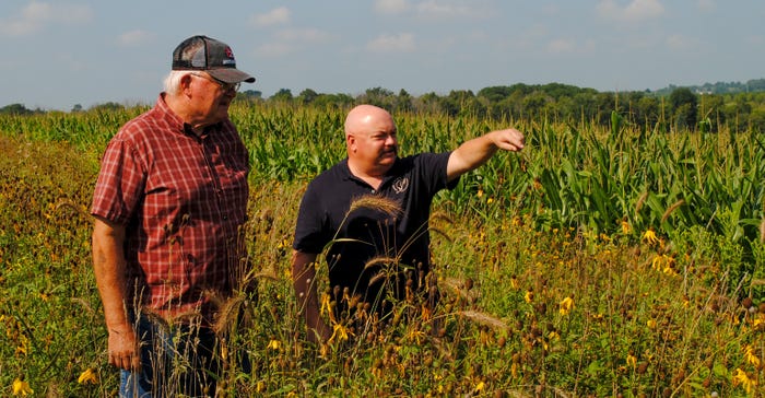 Greg Olson, soil and water conservationist for Sand County Foundation and Kewaskum farmer Dan Stoffel check out flowers and grasses