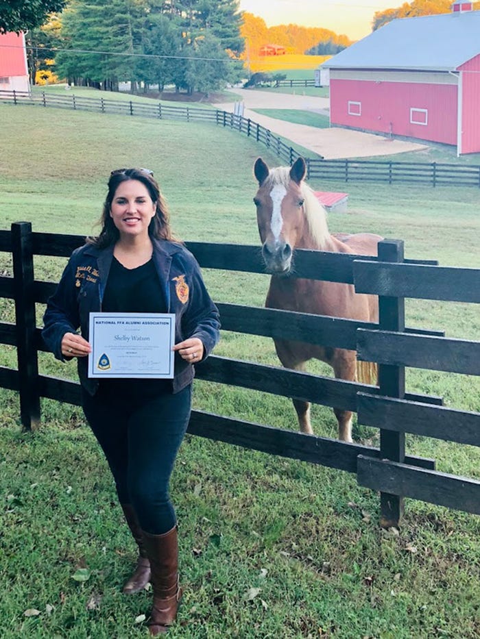 Shelby Watson-Hampton, an FFA Alumni Lifetime Member, holds up her certificate