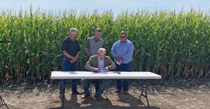 Minnesota Gov. Tim Walz, seated at table, signs executive order establishing Governor’s Biofuels Council, flanked by Gary A