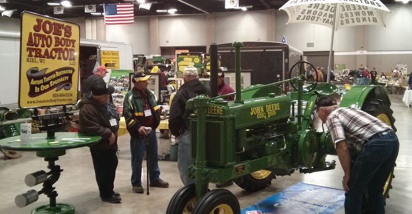 visitors attending the 11th Gathering of the Green Conference looking at a John Deere tractor