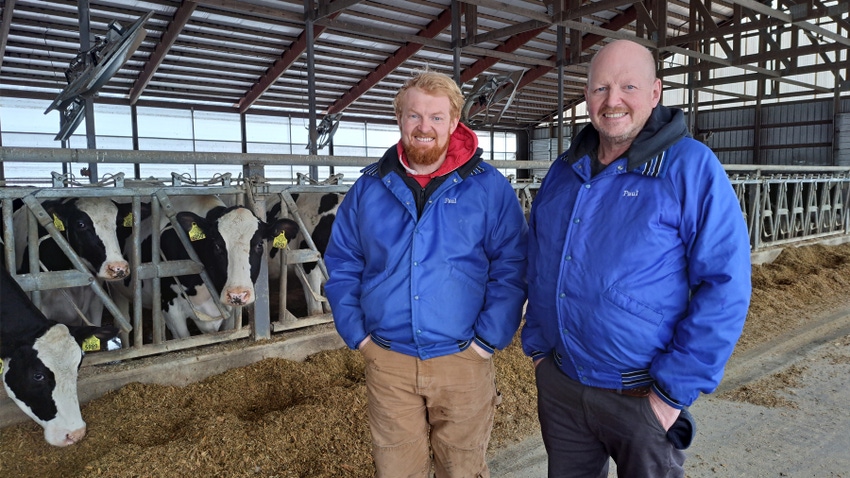  Matt Lippert and his son Paul on their dairy farm with cows in background