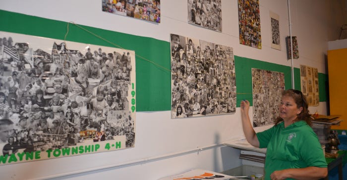 Alice Sweeney points to posters showing the history of Wayne Township 4-H