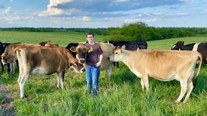 Cade Claycomb in a field with dairy cows