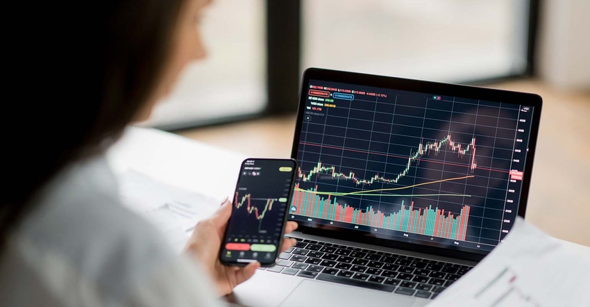 woman analyzes market chart on laptop and phone