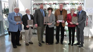 Six people holding five Master Farmer plaques altogether