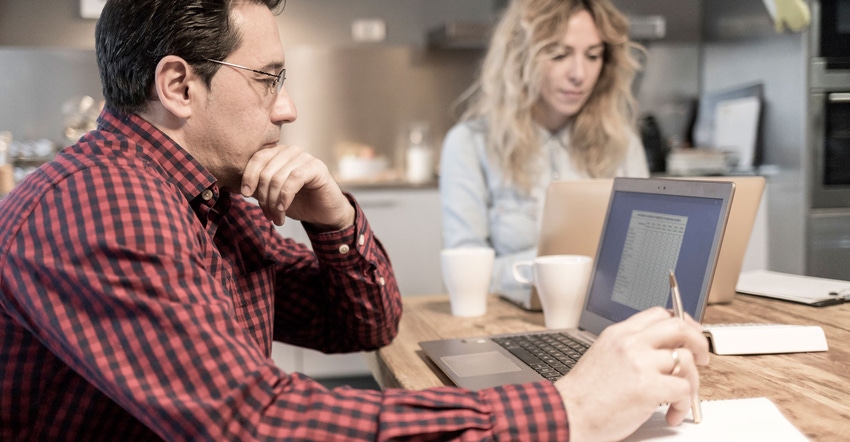 man and woman working on laptops at table