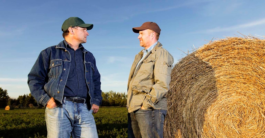 two farmers in a field talking