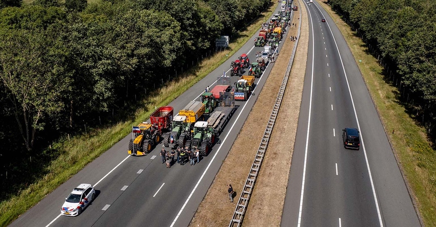 Line of dutch farmers on tractors backed up on highway