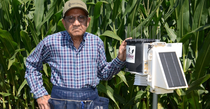 Dave Nanda standing next to a Spectrum Technologies weather station in a cornfield