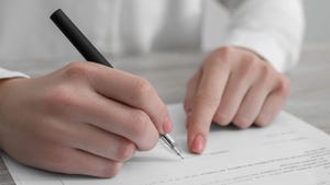 Close-up of a woman signing a document