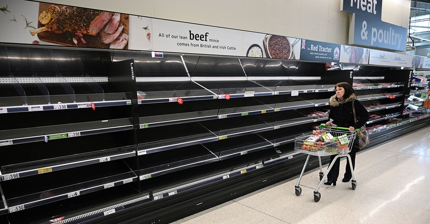 A shopper walks past empty food shelves amidst the novel coronavirus COVID-19 pandemic, in Manchester, northern England on Ma