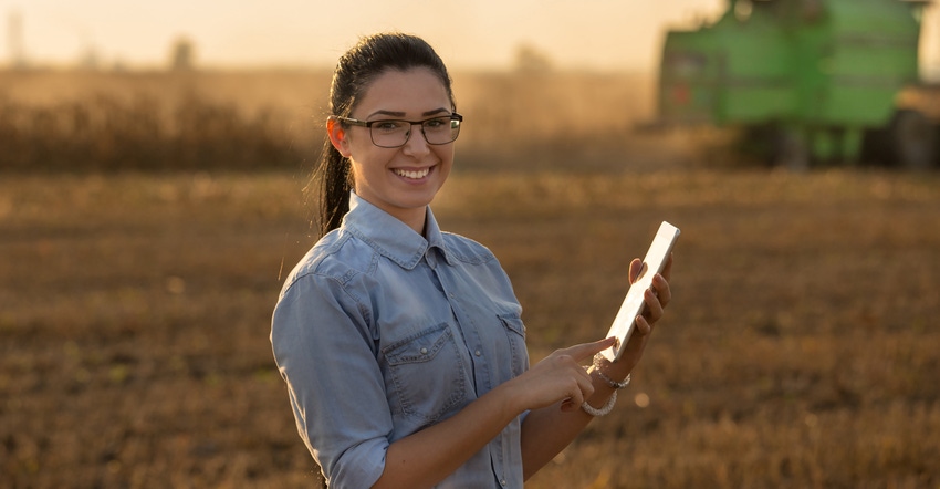 Woman in field holding tablet
