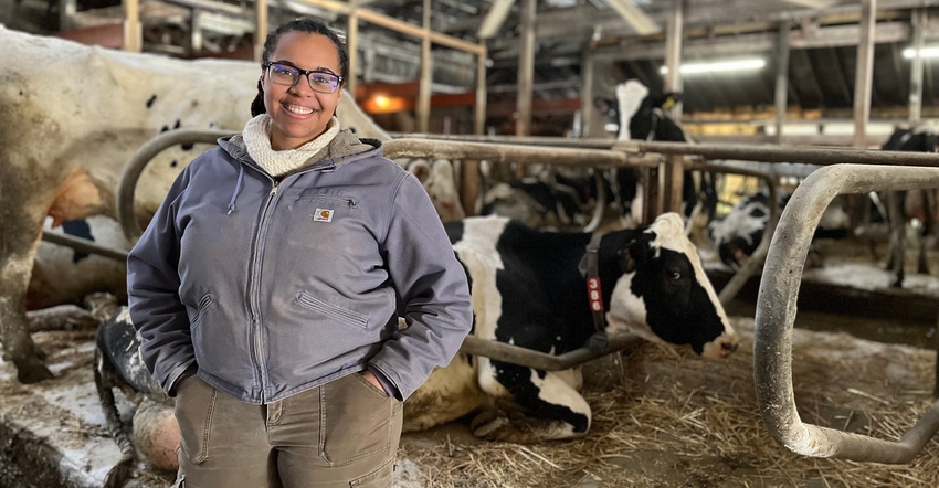 Dana Adams, University of Minnesota Extension livestock educator, standing in barn with dairy cows