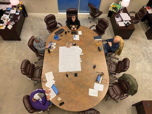 Overhead view of people social distanced around a conference table.