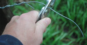 closeup of hand cutting wire