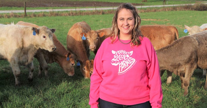Savannah Moore standing with beef cattle in pasture Savannah Moore standing with beef cattle in pasture