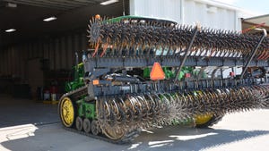 A rotary hoe mounted on a tractor with tracks