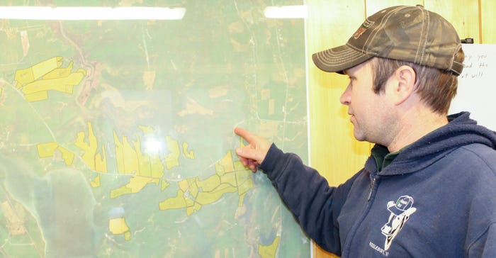 Farmer Jon Lucas points to a wall map of his fields which drain into nearby Lake Champlain