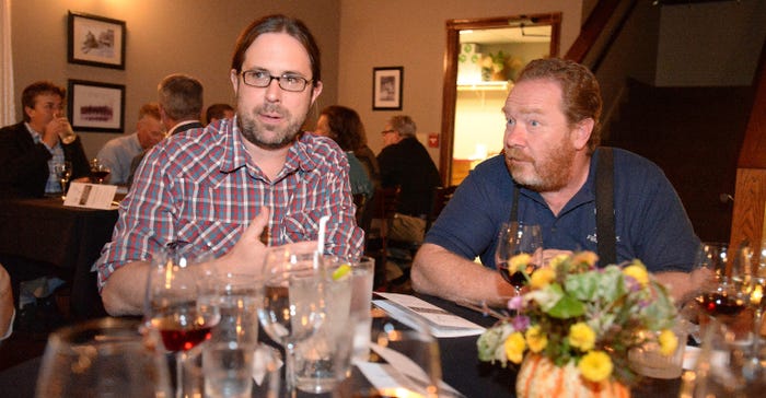 Agricultural marketing specialist Matt LeRoux, left, talks with farmers and consumers at a "Meat Your Farmer" dinner event