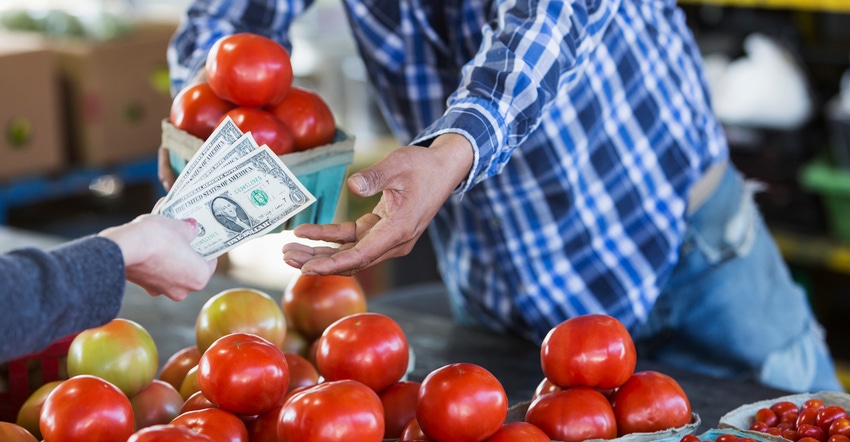 customer paying for tomatoes at produce stand