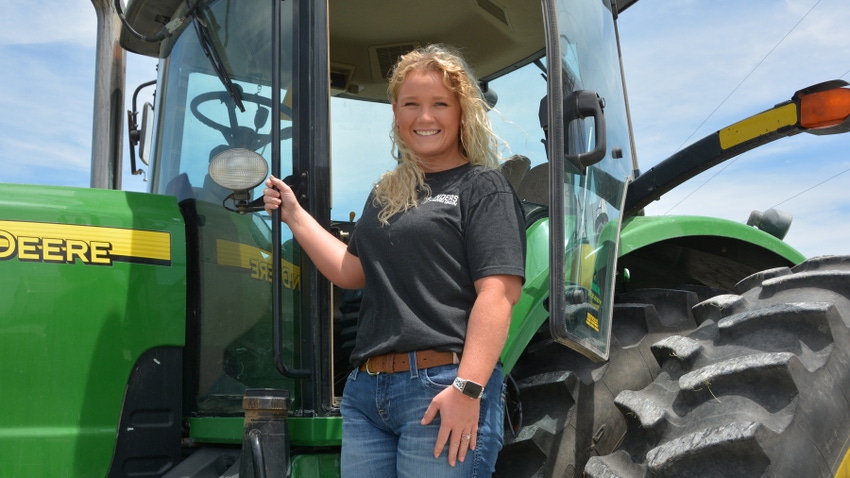 Rachel Hyde standing on John Deere tractor