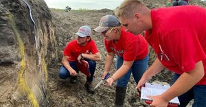 Members of the UNL Soil Judging Team get their feet wet in the soil pit during competitions
