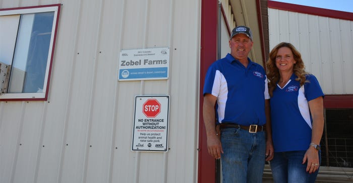 Larry and Tami Zobel in front of their office on their farm.