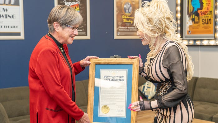 Gov. Kelly and Dolly Parton hold framed proclamationi