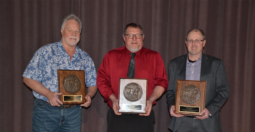 Three men each holding a Master Farmer plaque award