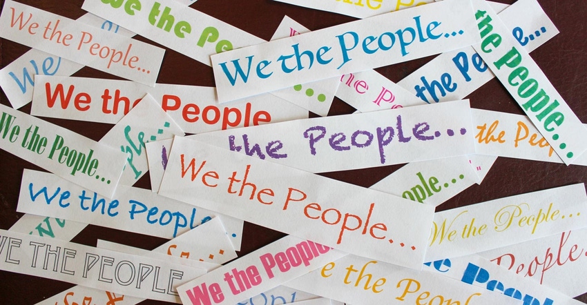 A collage with the saying of "we the people" in different colors on cut pieces of paper