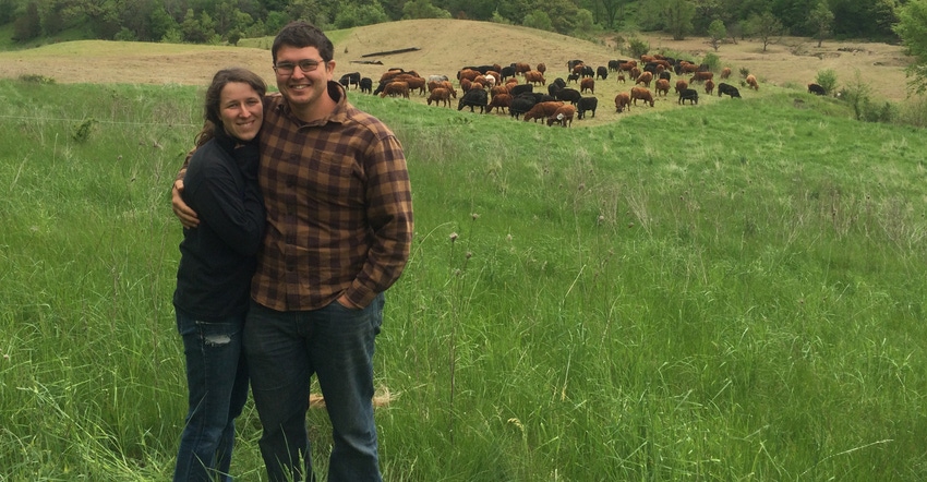 Kayla Koether and Landon Corlett stand near grazing cattle