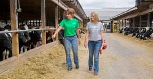 Cortney VanOeffelen, who owns the dairy with her three sisters, walks through the farm with her niece, Torri Hawkins, who she
