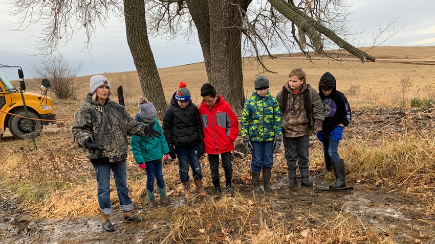 students in field with teacher