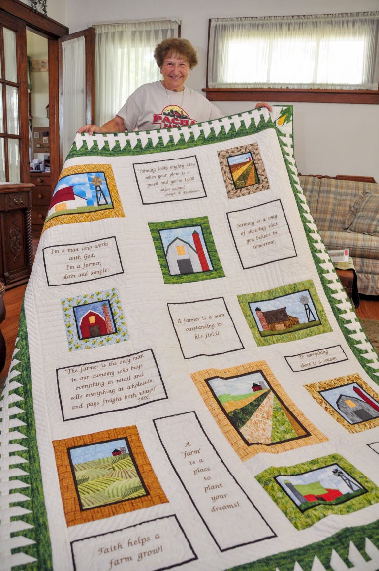 Rosemary holds up her favorite quilt, one she crafted for her husband Gerald that showcases some of his favorite sayings