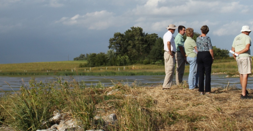 men and women looking at flooded farmland