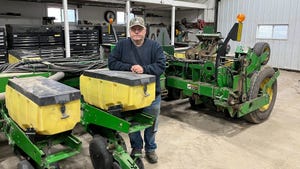 Minnesota farmer Bob Worth stands next to farm equipment.