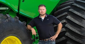 Seth Lawrence in front of large tractor tires