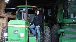 Janis Highley, Indiana Farm Bureau Second Vice President, stands on the steps of a John Deere tractor