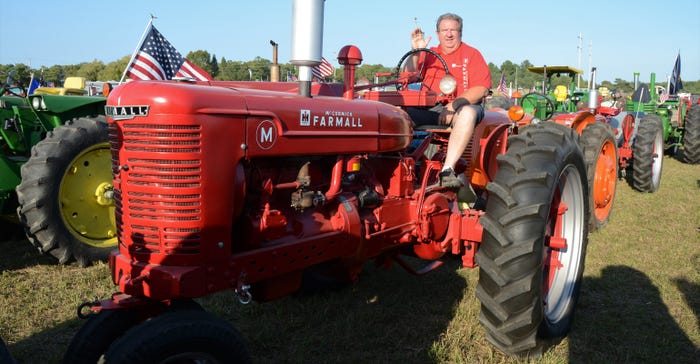 Bruce Kittle sits in the driver seat of a 1947 Farmall M tractor