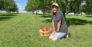 Becky Housberg shows off a half-bushel of apples 