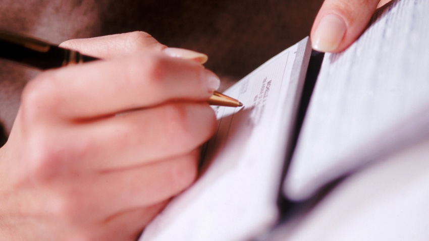 close-up of hand signing a document